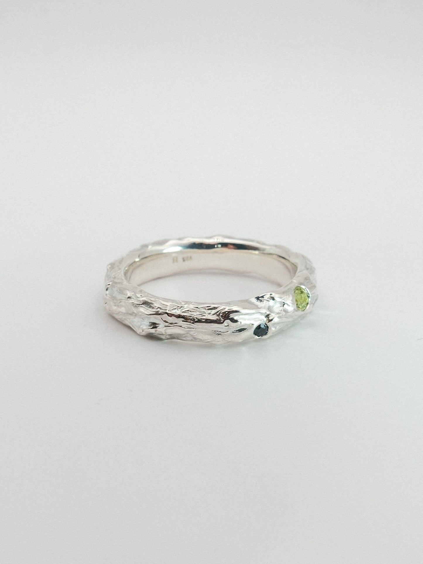 sterling silver with green and dark blue gemstone on a white background