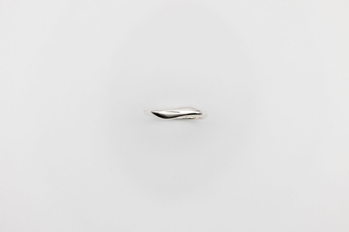 Thin organic Berhel silver ring on a light gray background