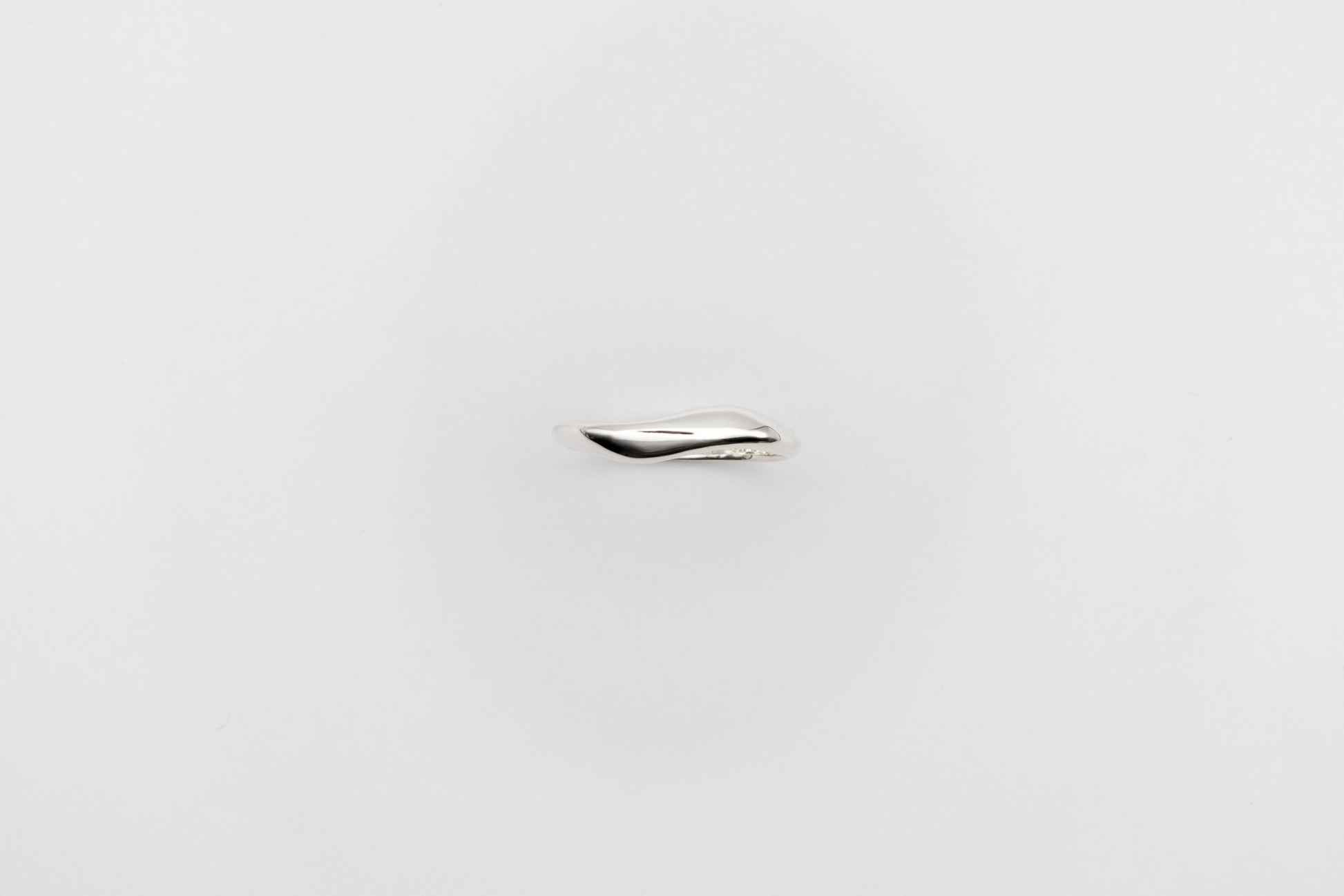 Thin organic Berhel silver ring on a light gray background