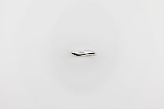 Thin organic Berhel silver ring on a light gray background