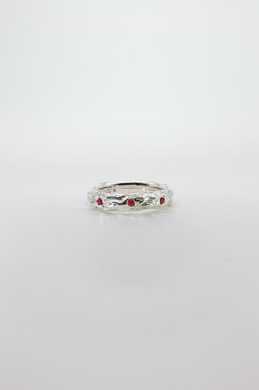 Silver ring with red rubies on a white background