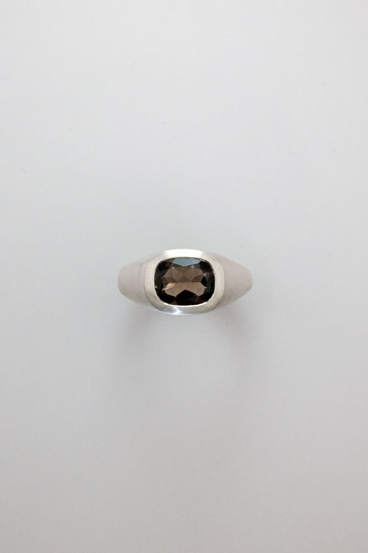 Silver ring with a smoky gemstone on a light gray background