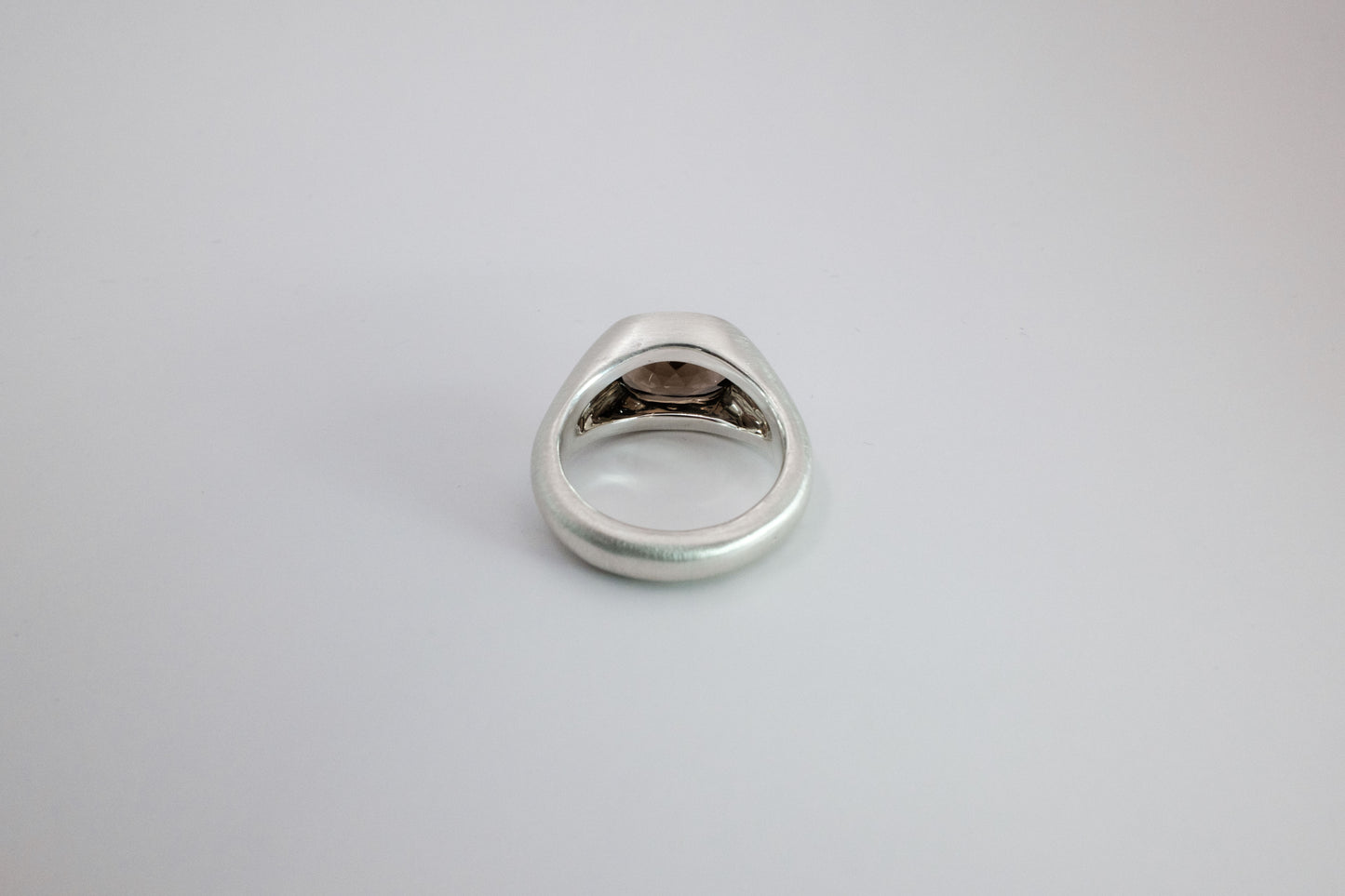 Silver ring on a light gray background