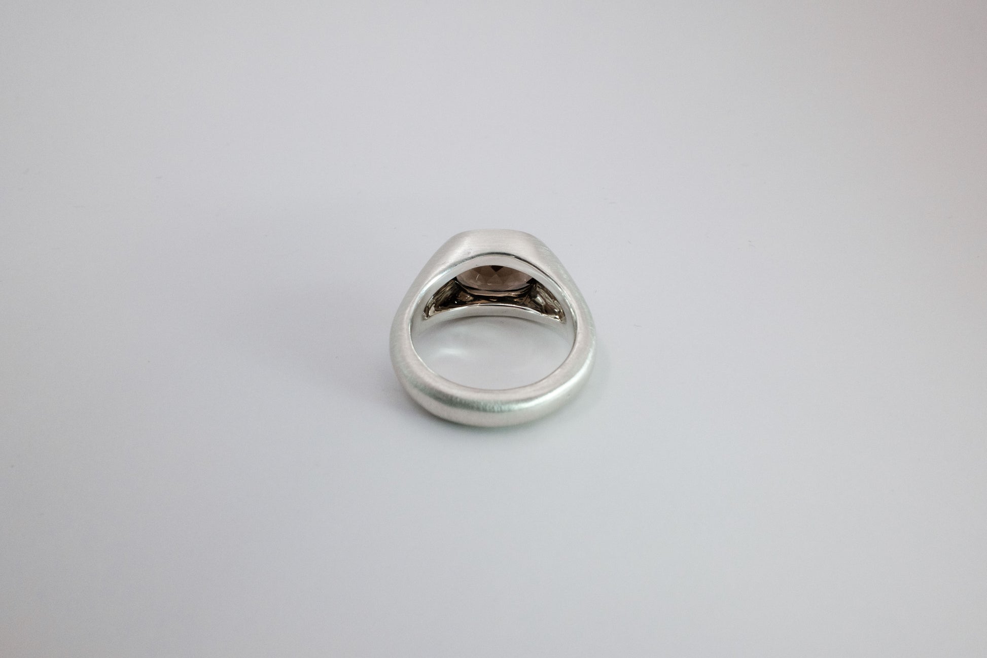 Silver ring on a light gray background