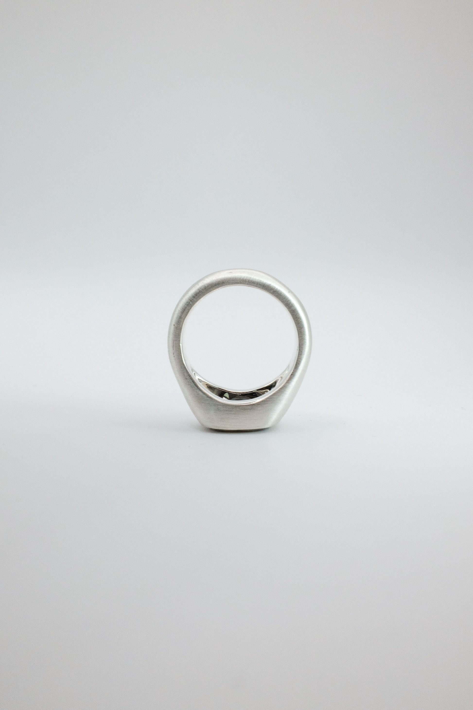Silver ring on a light gray background