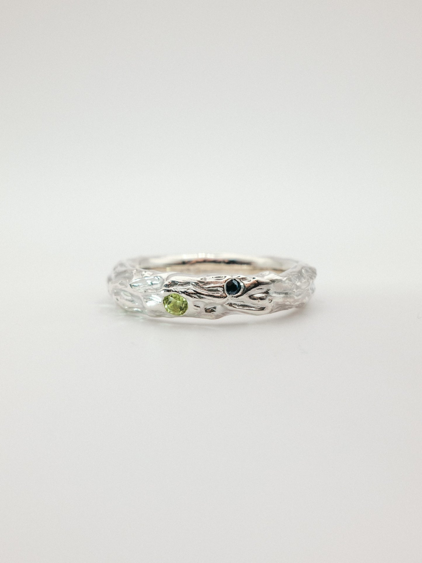 sterling silver with green and dark blue gemstone on a white background
