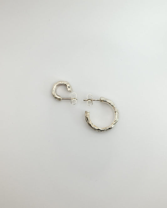 Silver hoop earrings on a light gray background