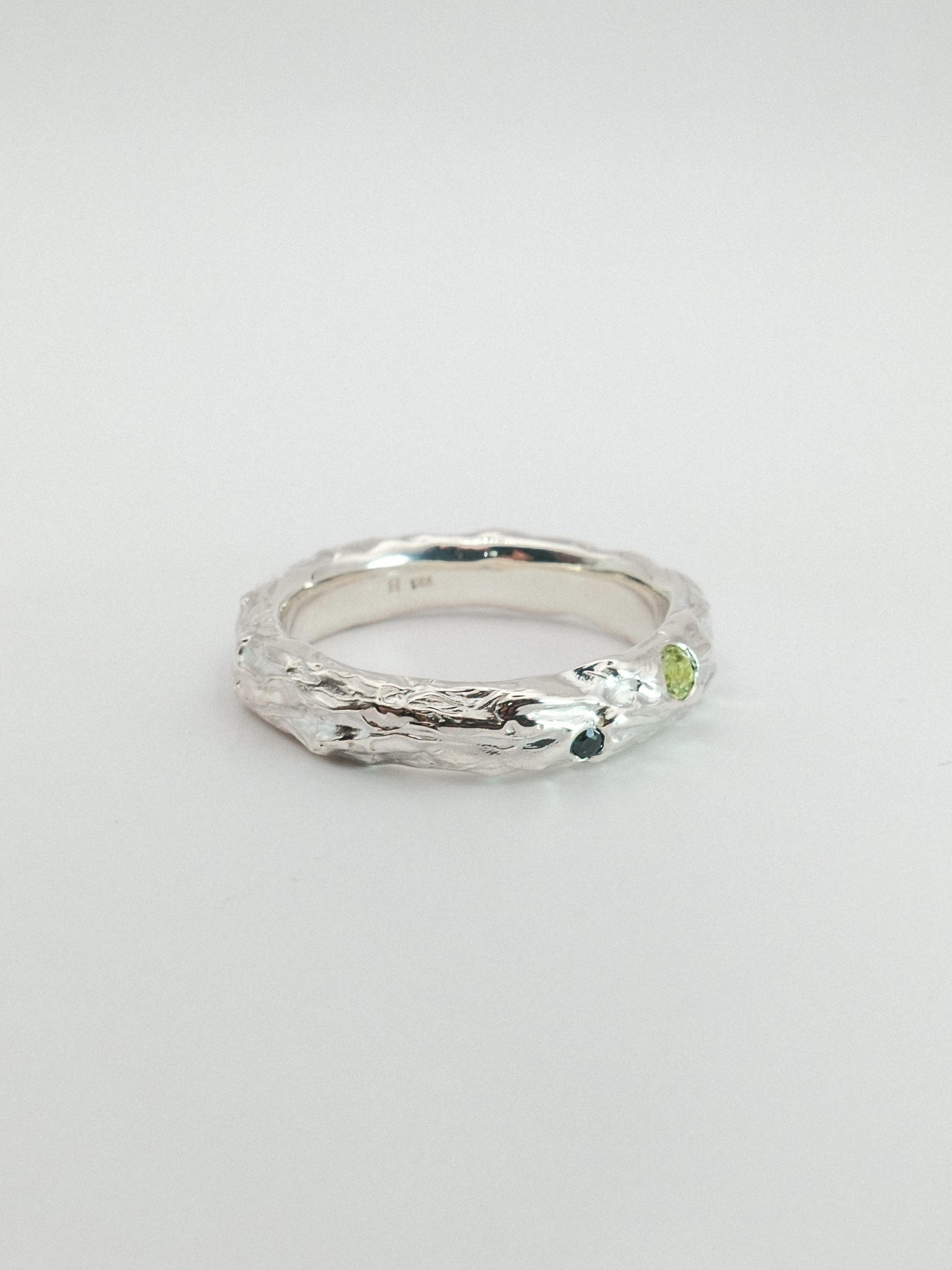sterling silver with green and dark blue gemstone on a white background
